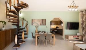 a dining room with a table and a spiral staircase at Villa Aelia Luxury Maisonette in Salamina
