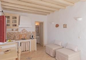una cucina e un soggiorno con pareti bianche di Kalderimi Residencies a Astypalaia Town