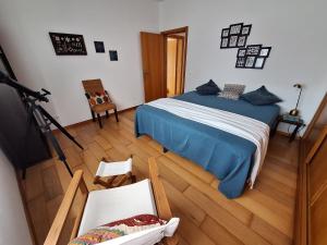 een slaapkamer met een bed en stoelen bij Oceanus in Horta