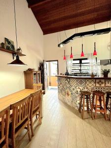 una cocina con una barra con mesas y sillas de madera en Novo Duplex em condomínio com piscina Juquehy, en São Sebastião