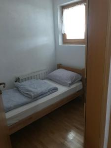 a small bedroom with a bed and a window at Vila Damir in Gornja Šišava