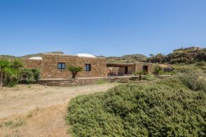 a brick house in the middle of a field at Dammuso Meraki in Pantelleria