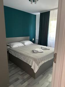a bedroom with a bed with two towels on it at Apartament Nina in Bucharest