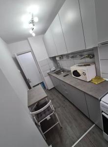 a kitchen with white cabinets and a white microwave at Apartament Nina in Bucharest +2 photos