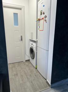 a kitchen with a refrigerator and a washing machine at Apartament Nina in Bucharest