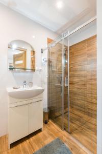 a bathroom with a sink and a shower at Apartamenty Zatoka Relaksu Sauna i Balia in Polańczyk