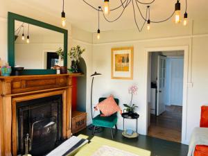 un salon avec une cheminée et un miroir dans l'établissement Awelfa a peaceful cottage in the Cambrian mountains, à Llanbrynmair