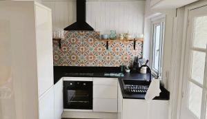 une cuisine avec des armoires blanches et un four à plaques de cuisson dans l'établissement Awelfa a peaceful cottage in the Cambrian mountains, à Llanbrynmair 31 autres photos