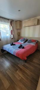 une chambre avec un grand lit avec une couverture rouge dans l'établissement Mobil home camping Siblu des embruns, à Lège-Cap-Ferret