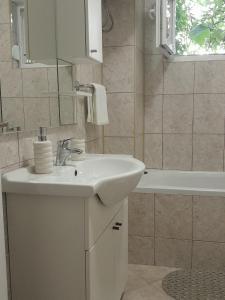 a bathroom with a white sink and a bath tub at Vacanza apartment in Mostar