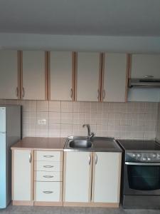 a kitchen with white cabinets and a sink at Vacanza apartment in Mostar