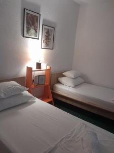 a hotel room with two beds and a night stand with a lamp at Vacanza apartment in Mostar