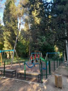 a playground with benches and swings in a park at Vacanza apartment in Mostar