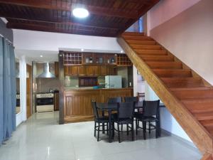 a kitchen with a table and chairs and a staircase at Rincón soñado para 8 personas in Puerto Iguazú