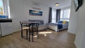 a small room with a bed and a table and chairs at Diana Playa in Benalmádena
