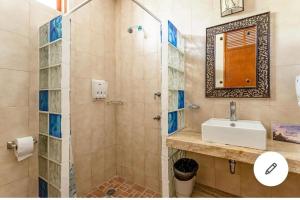 a bathroom with a sink and a shower with a mirror at HOTEL VILLAS XAIBA in Puerto Escondido
