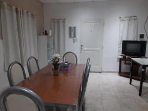 a dining room with a wooden table and a television at Amalia Chacra Hospedaje in Gualeguay +9 photos