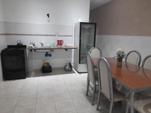 a dining room with a table and chairs and a kitchen at Amalia Chacra Hospedaje in Gualeguay