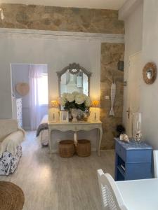 a living room with a table with flowers and a mirror at Casita Boutique en la playa in Sant Antoni de Calonge