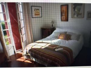 een slaapkamer met een bed in een kamer met ramen bij Argizaria in Ciboure +6 foto's