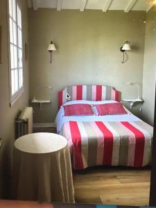 een slaapkamer met een bed met een rode en witte gestreepte deken bij Argizaria in Ciboure