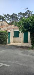 a building with green doors on the side of a street at domino in Saint-Georges-dʼOléron