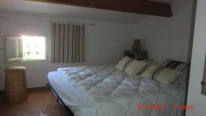 a bedroom with a large white bed with a window at domino in Saint-Georges-dʼOléron