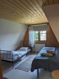 a bedroom with two beds and a wooden ceiling at Villa Freia in Nukari