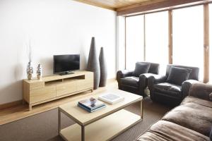 ein Wohnzimmer mit Sofa und Fernseher in der Unterkunft Cap 1500 by FeelFree Rentals in Baqueira-Beret