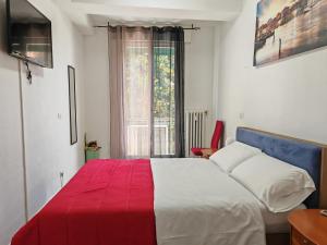 a bedroom with a red and white bed and a window at Goldmine Guest House 1 in Venice
