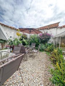 a patio with a table and chairs and an umbrella at Hotel Posada de Santa Elena in Tunja