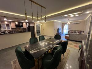 a living room with a table and chairs and a couch at Pyramids Luxury apartment in Cairo