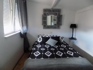 サン・マルタン・ダルデーシュにあるB&B La Vieille Sourceのベッドルーム(白黒のベッド1台、鏡付)