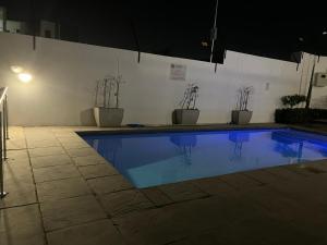 a swimming pool with potted plants and an umbrella at Cozy retreat in Carlswald 264 in Midrand