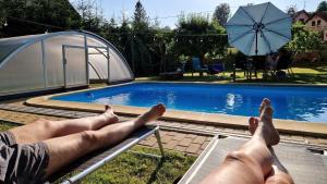 a man laying on a bench next to a swimming pool at Droom b&b Čermná in Čermná