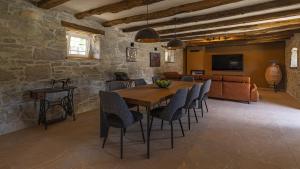 a dining room with a table and chairs and a couch at Villa Casa Pintori in Buzet