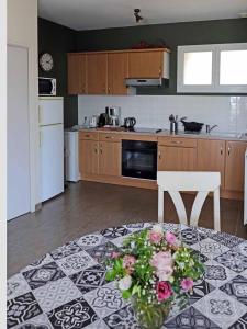 a kitchen with a table with a vase of flowers on it at Appartement les hirondelles in Saint-Pair-sur-Mer