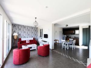 a living room with a red couch and a table at Appartement les hirondelles in Saint-Pair-sur-Mer
