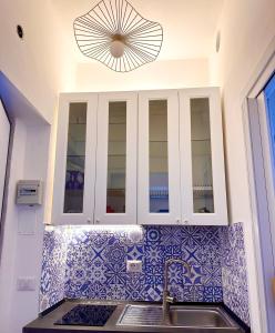 una cucina con lavandino e armadietto bianco di La 2 monolocale con accesso privato in spiaggia a Torvaianica