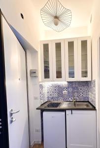 una cucina con mobili bianchi e un lavandino di La 2 monolocale con accesso privato in spiaggia a Torvaianica Altre 5 foto