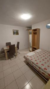 a bedroom with a bed and a desk and a table at Apartments Bojanic in Bar