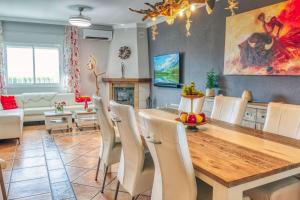 a dining room with a wooden table and chairs at Casa Hollandia in Viñuela