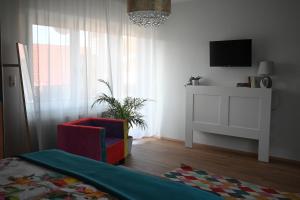 a living room with a chair and a television at Apartment Relax in Raskrižje