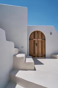 Pokój ze schodami i drewnianymi drzwiami w obiekcie The Mill Haven Santorini w mieście Oia