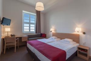 a hotel room with a bed and a desk and a television at Kardinal Schulte Haus in Bergisch Gladbach +46 photos