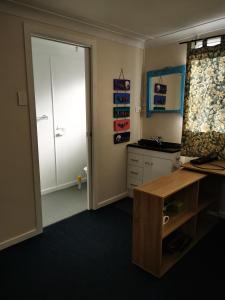 a room with a desk and a door to a kitchen at Affordable and convenient accommodation in Toowoomba