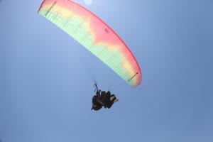 a paraglider flying in the sky at the bamboo Bali Cabin in Nusa Dua