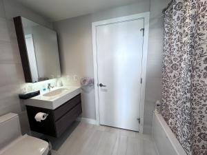 a bathroom with a sink and a toilet and a shower at Monthly stay-Relocation Special-New condo at Metrotown in Burnaby +7 photos