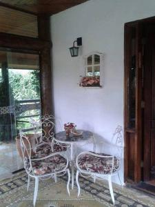 a white table and chairs in a room with a window at Casa dentro da floresta in Campos do Jordão +32 photos