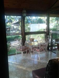 a patio with a table and chairs on a porch at Casa dentro da floresta in Campos do Jordão